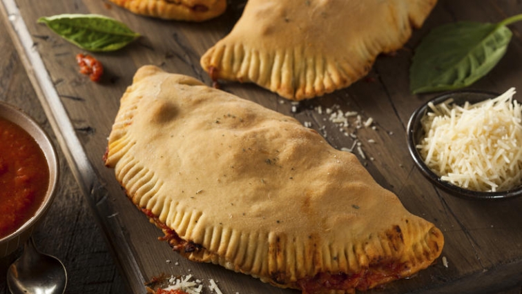 Italská pizza calzone plněná rajčatovou omáčkou a šunkou